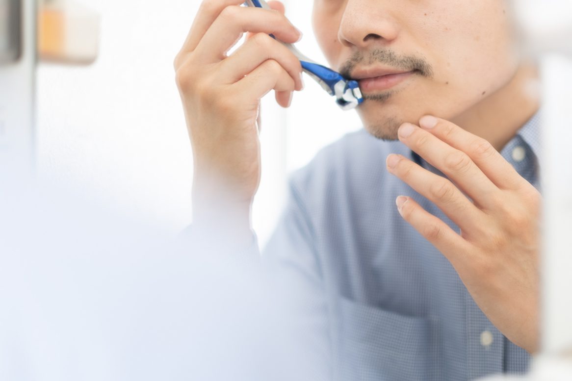 朝出勤前に髭を剃る男性