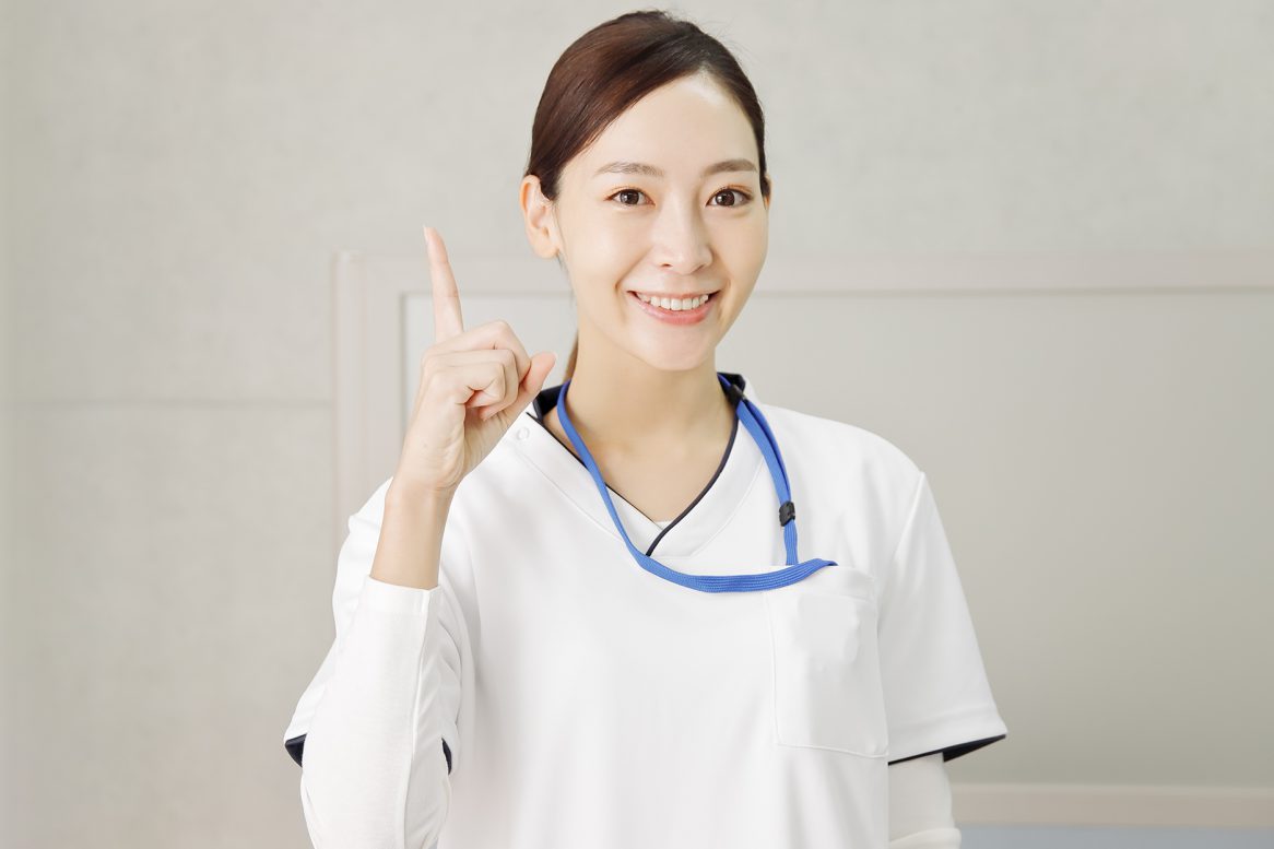 指差しポーズの笑顔の看護師の女性