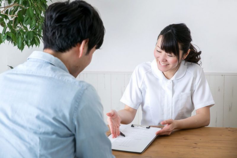 カウンセリングする白衣の女性