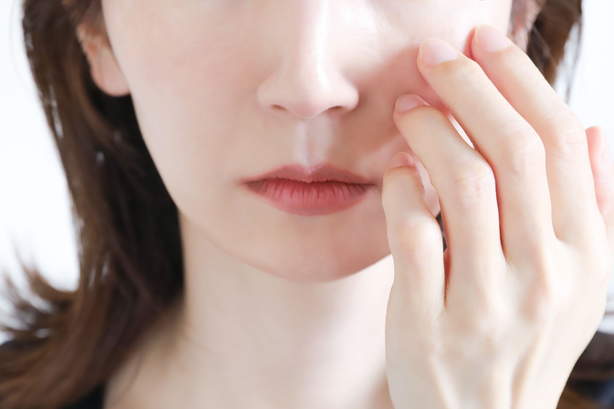 目の下のくぼみやシワを気にしている女性