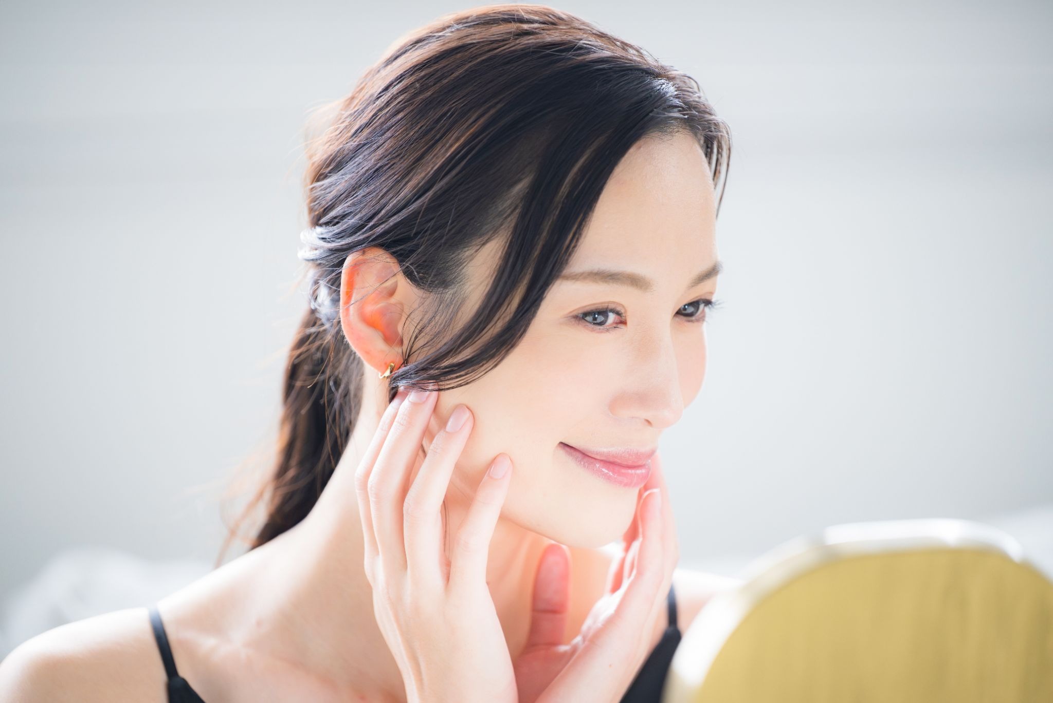 鏡を見て笑顔の女性
