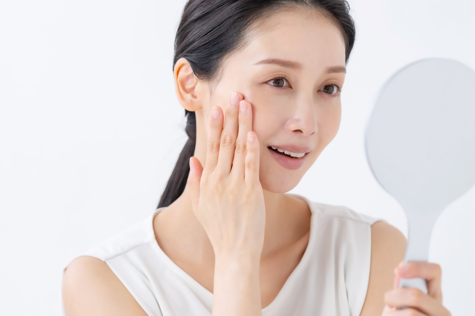 たるみを気にして鏡を見る女性