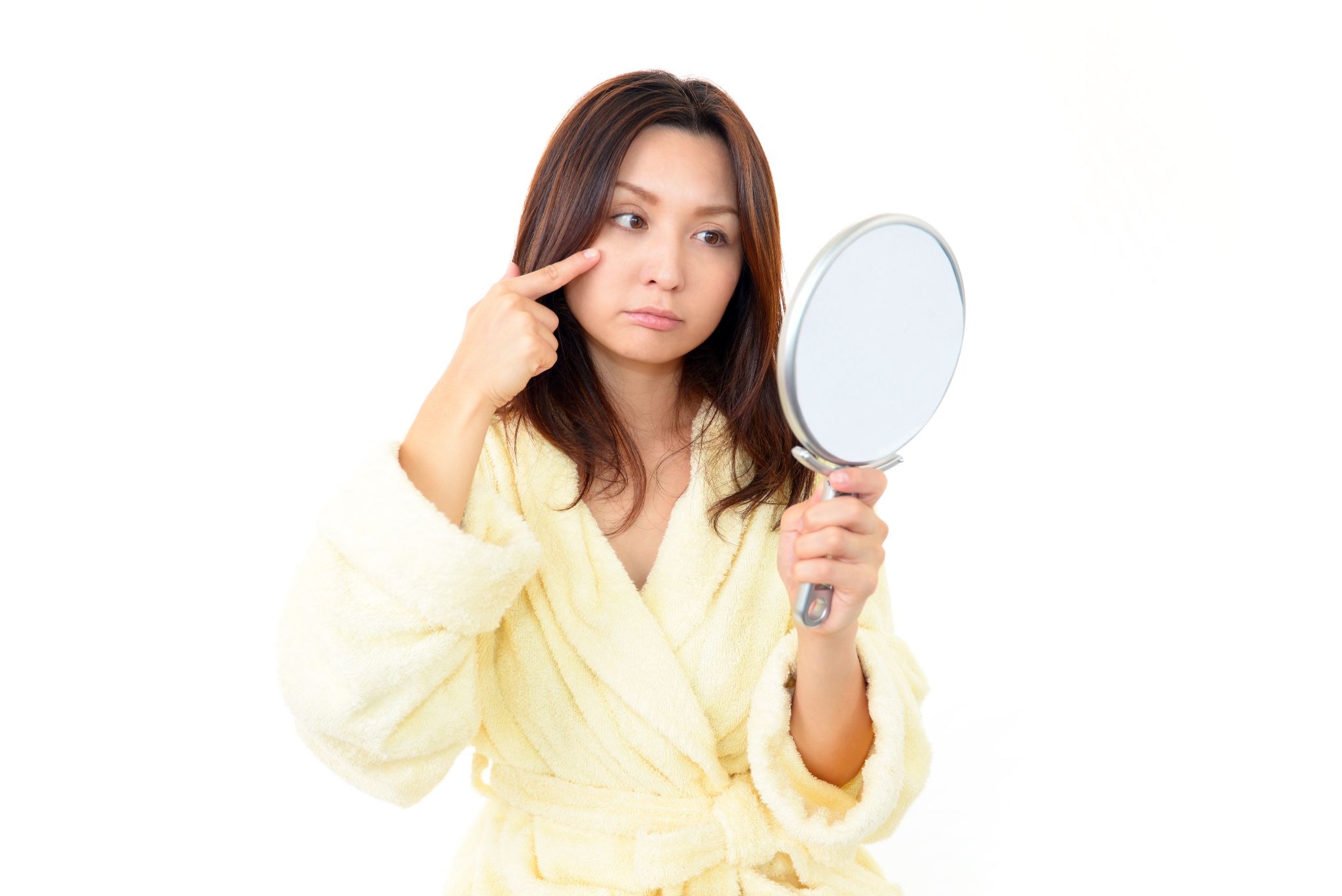 鏡を見てしわを気にしている女性