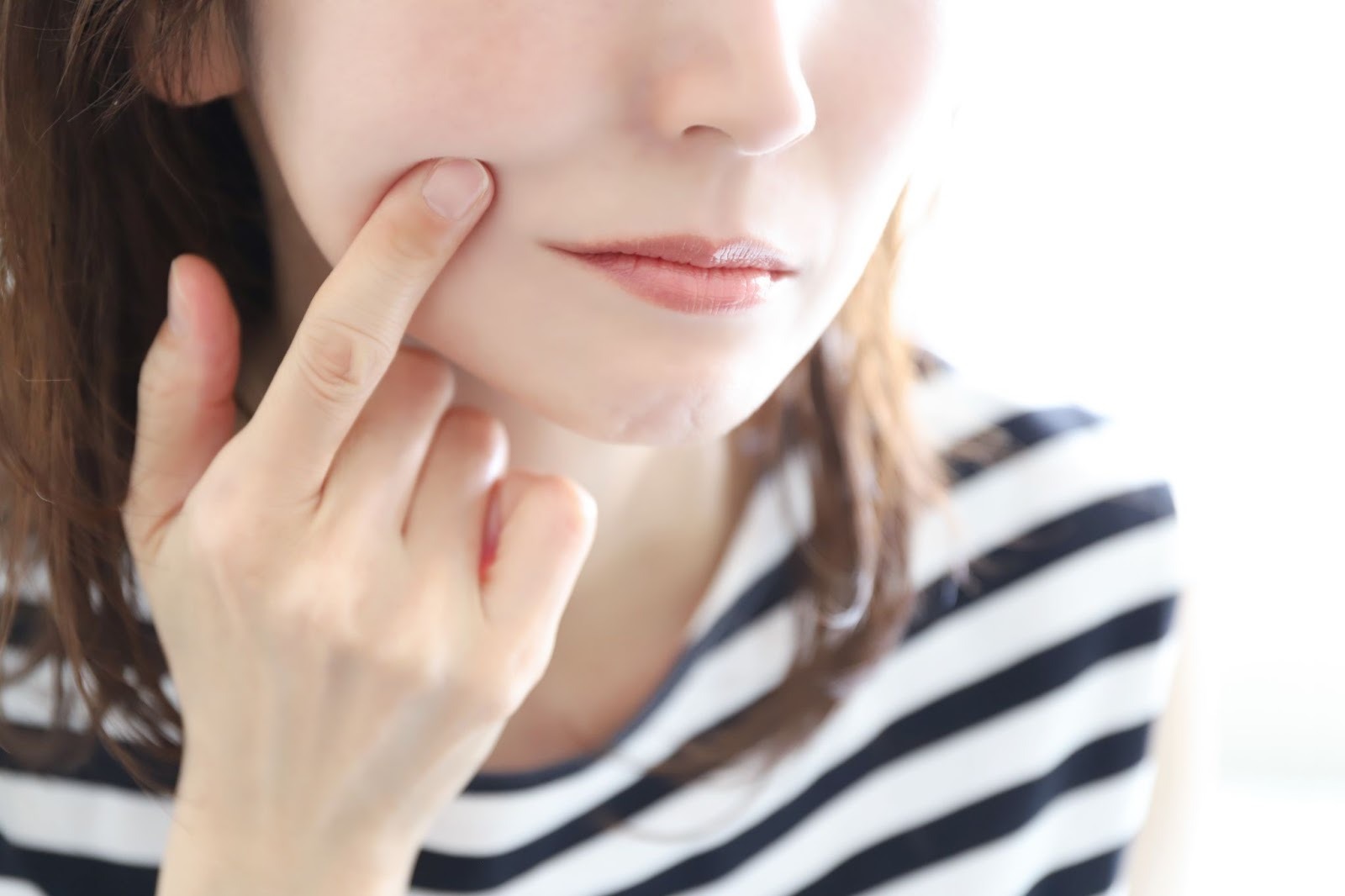 シミを気にして肌をチェックしている女性