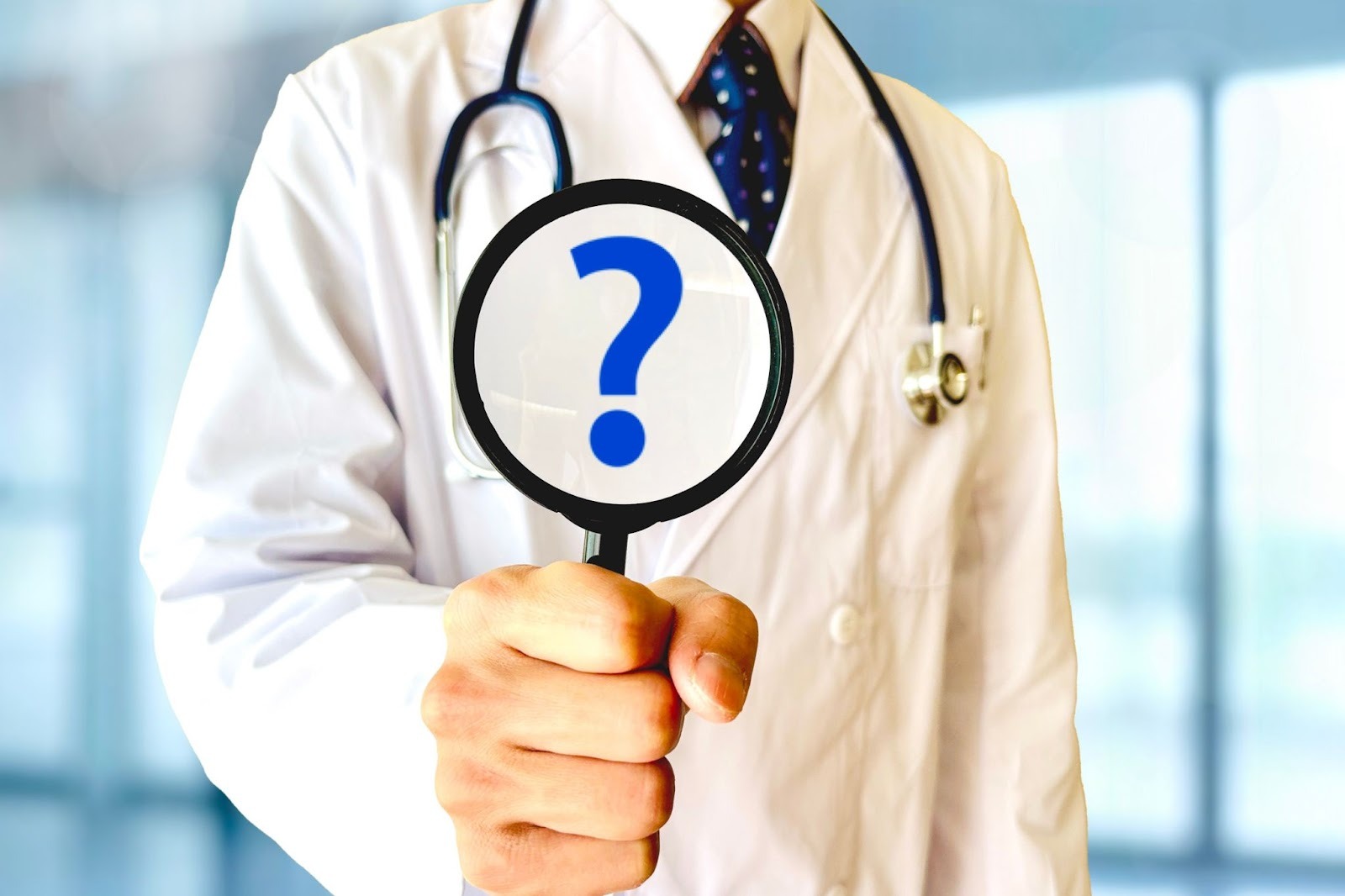 はてなマークが表示された虫眼鏡を持っている医師
