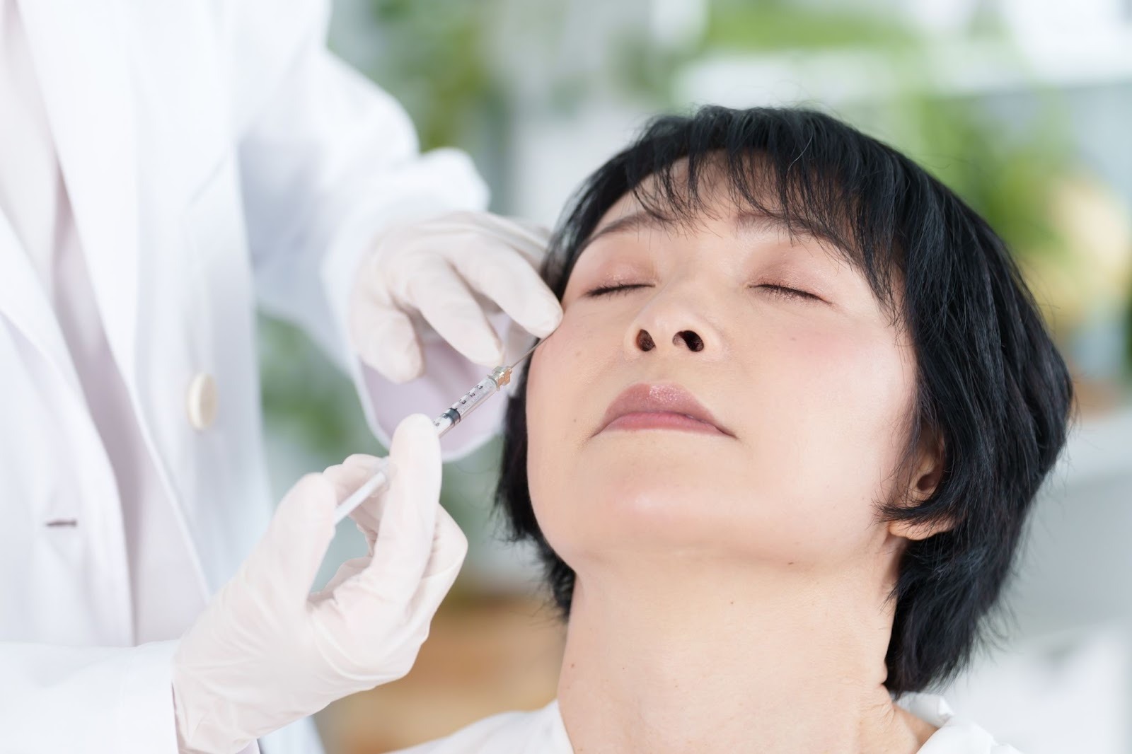 クリニックでヒアルロン酸注入による目の下のたるみ治療を受けている女性