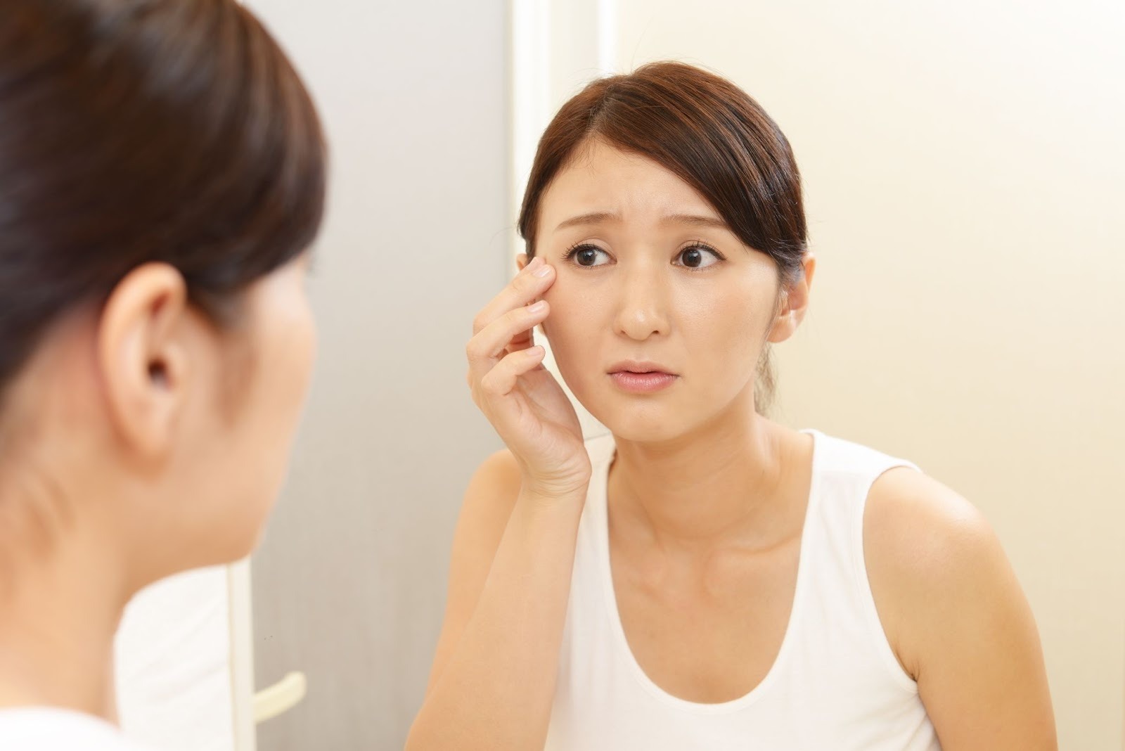 急に増えたシミを気にしている女性