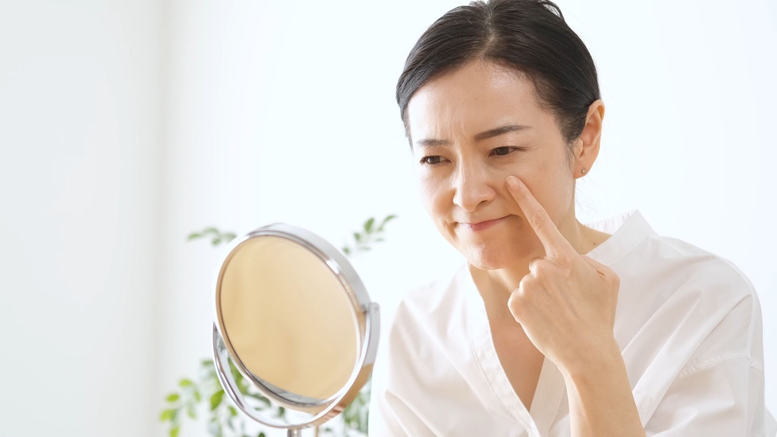 顔のしわを気にして鏡を見ている女性