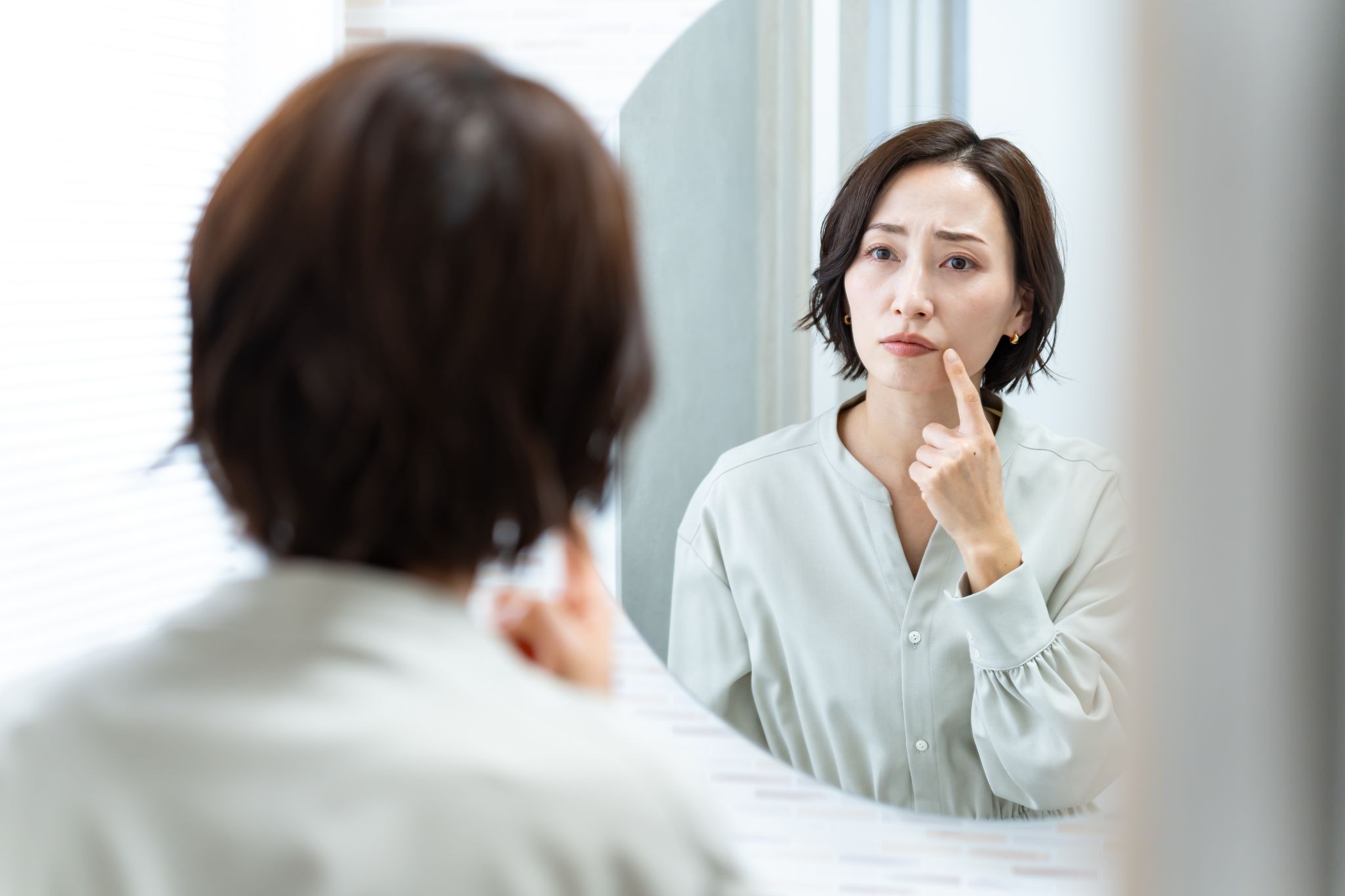 顔のたるみを気にしている女性