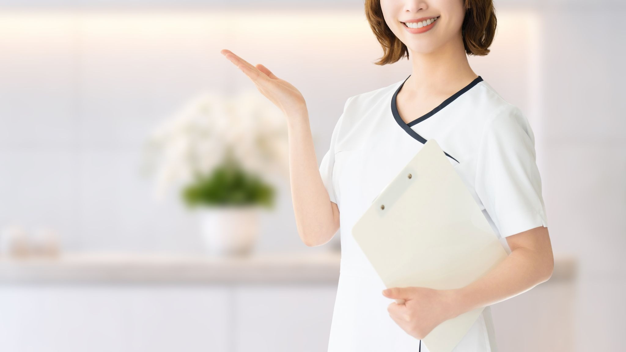 片手を上げている美容クリニックのスタッフの女性