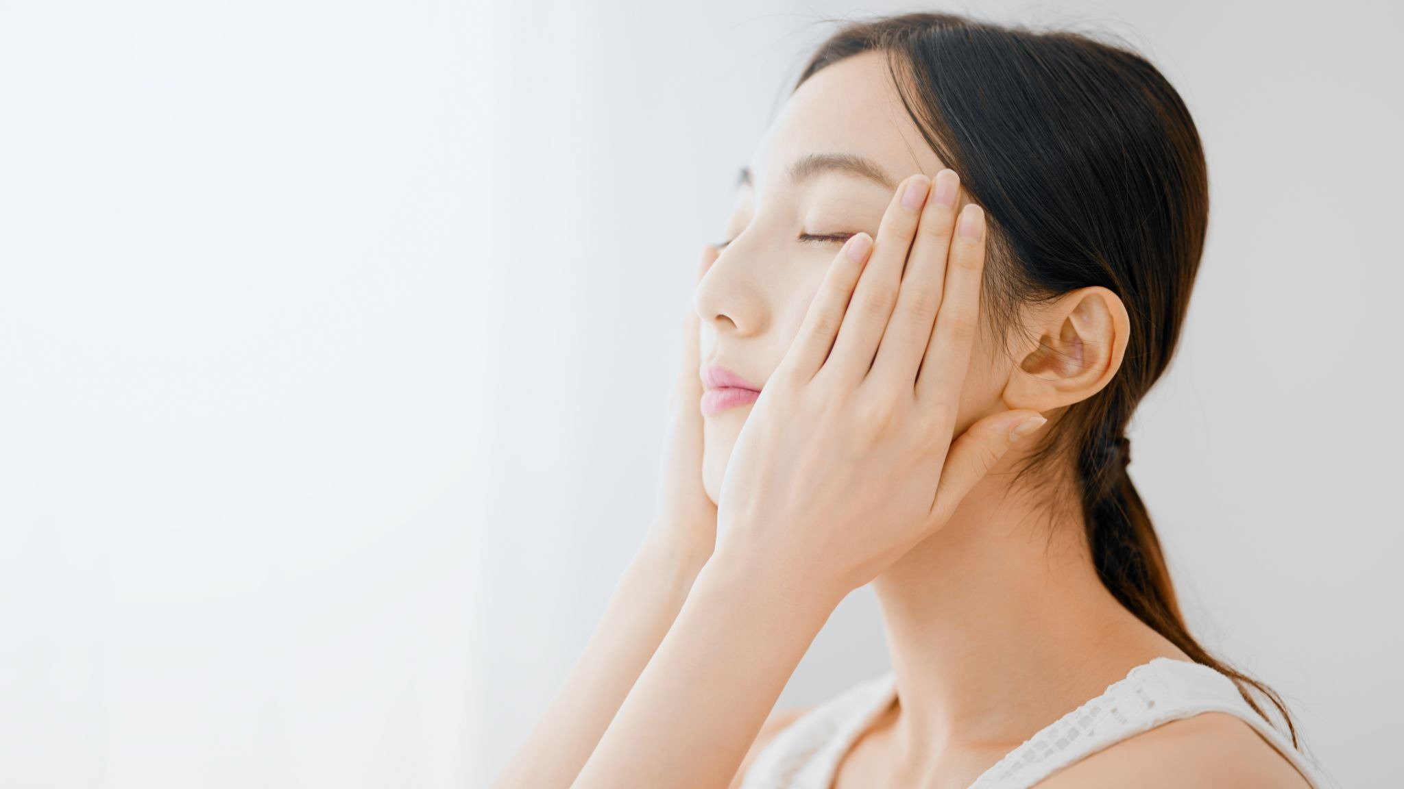 目と目の間の横じわ対策としてスキンケをしている女性