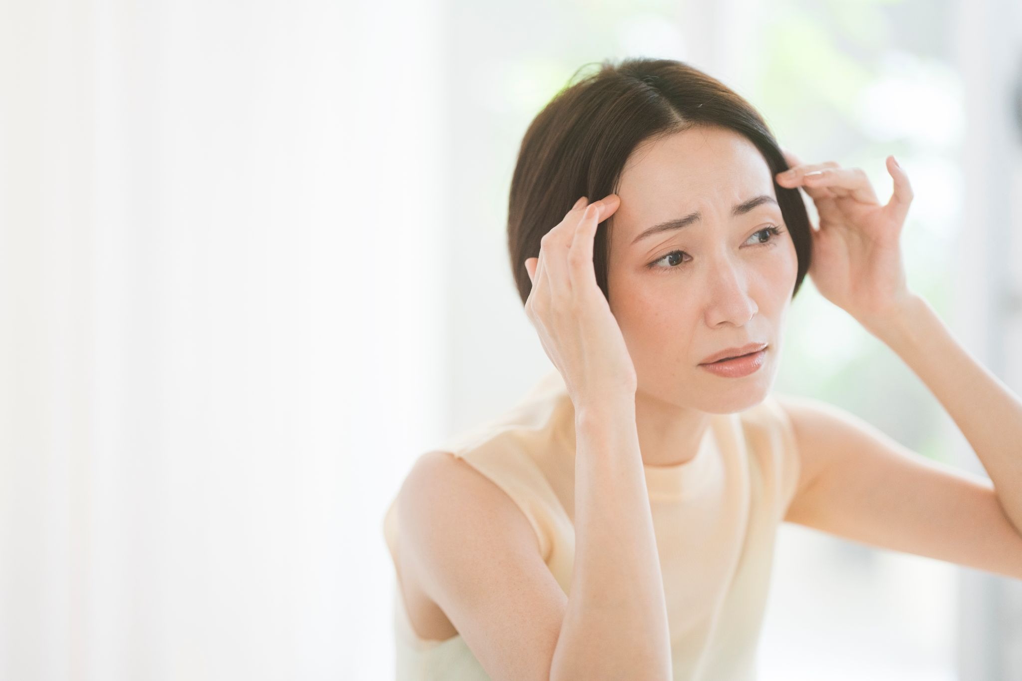 おでこのしわを気にしている30代女性